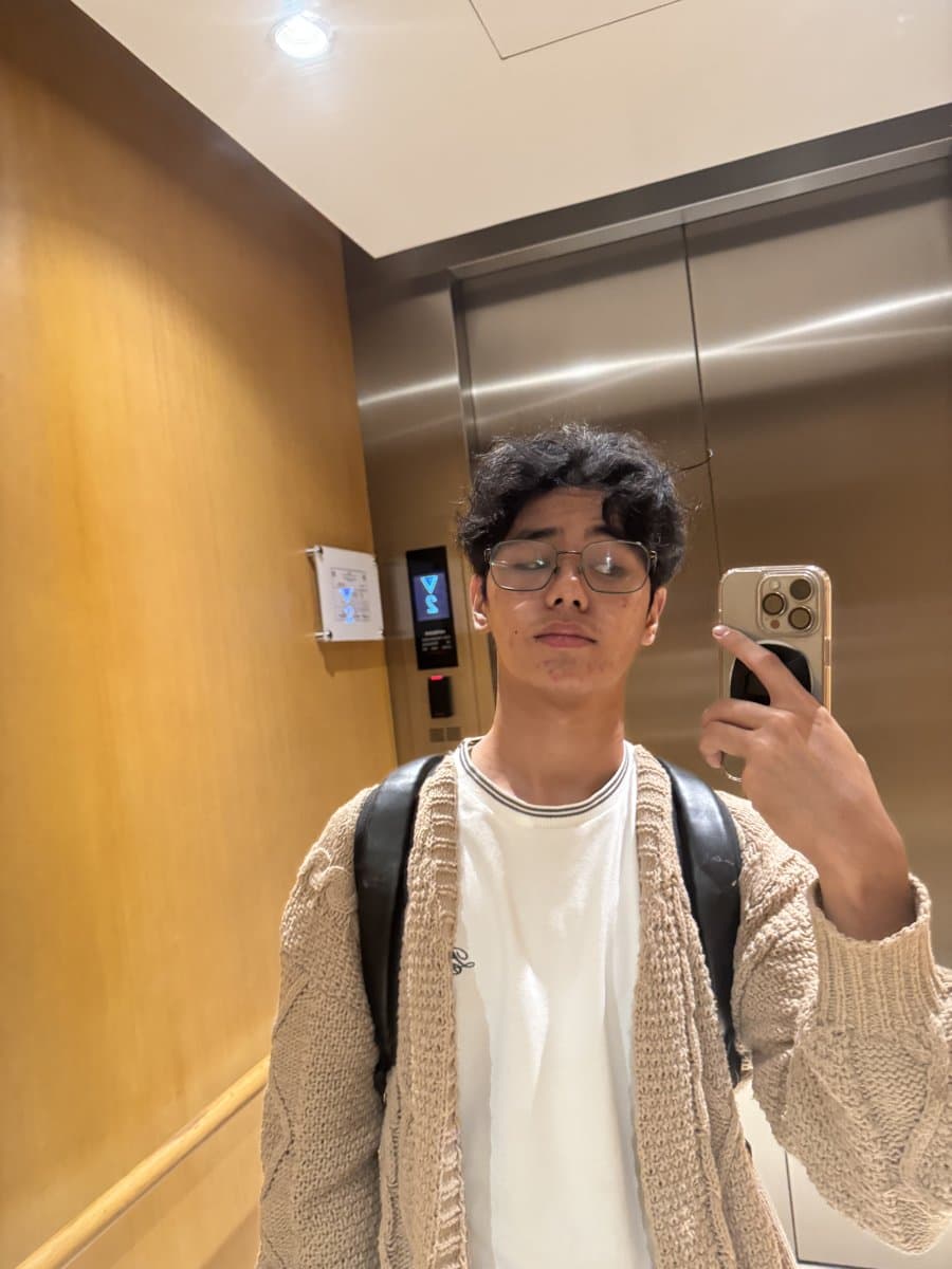 MarWie taking a mirror selfie in a cream cardigan and glasses